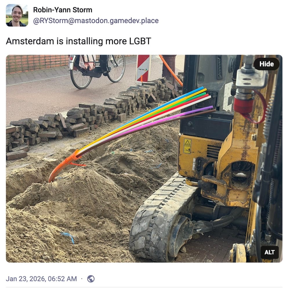 Robin-Yann Storm post on Mastodon: "Amsterdam is installing more LGBT" with a screenshot of a digger, a road pit, and a thick orange cable poking out of the ground with a ton of multi-colored rainbow fiber strands.