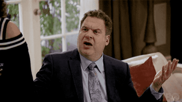 an animated gif from Curb Your Enthusiasm, of a man in a suit gesturing with this hands, and saying, "what the fuck?"