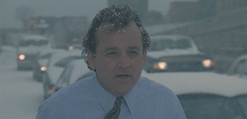 an animated GIF of Bill Murray outside in the snow, with just his dress shirt on, saying, "What blizzard? It's couple of flakes."