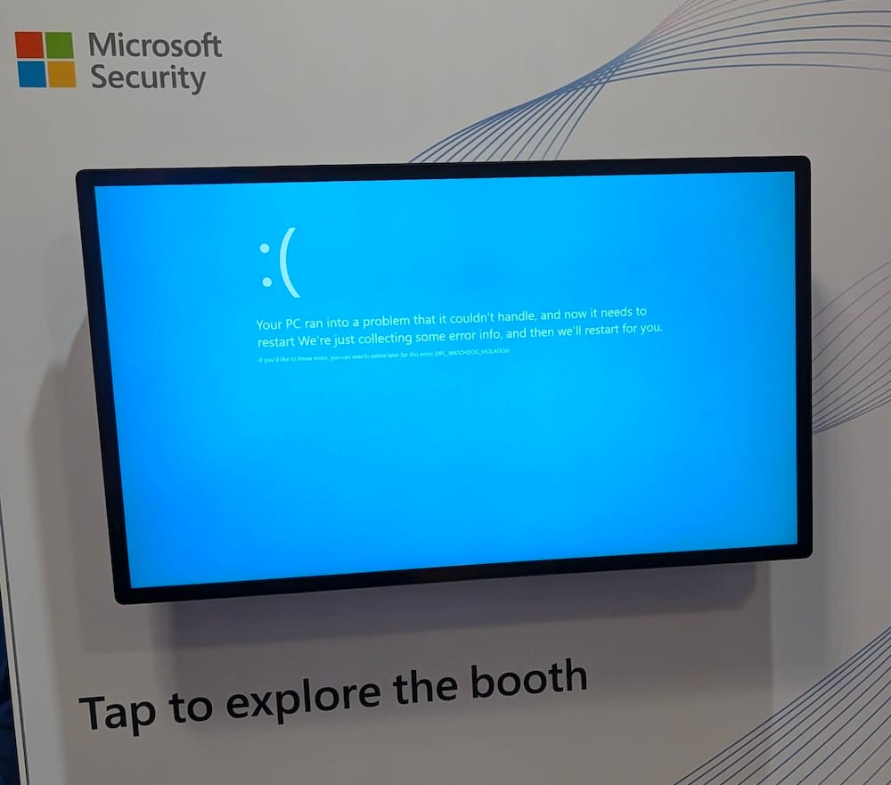 a photo via The Register of a Microsoft Security booth at the RSA conference, with a TV display containing what appears to be a Windows blue-screen-of-death, suggesting something went wrong.