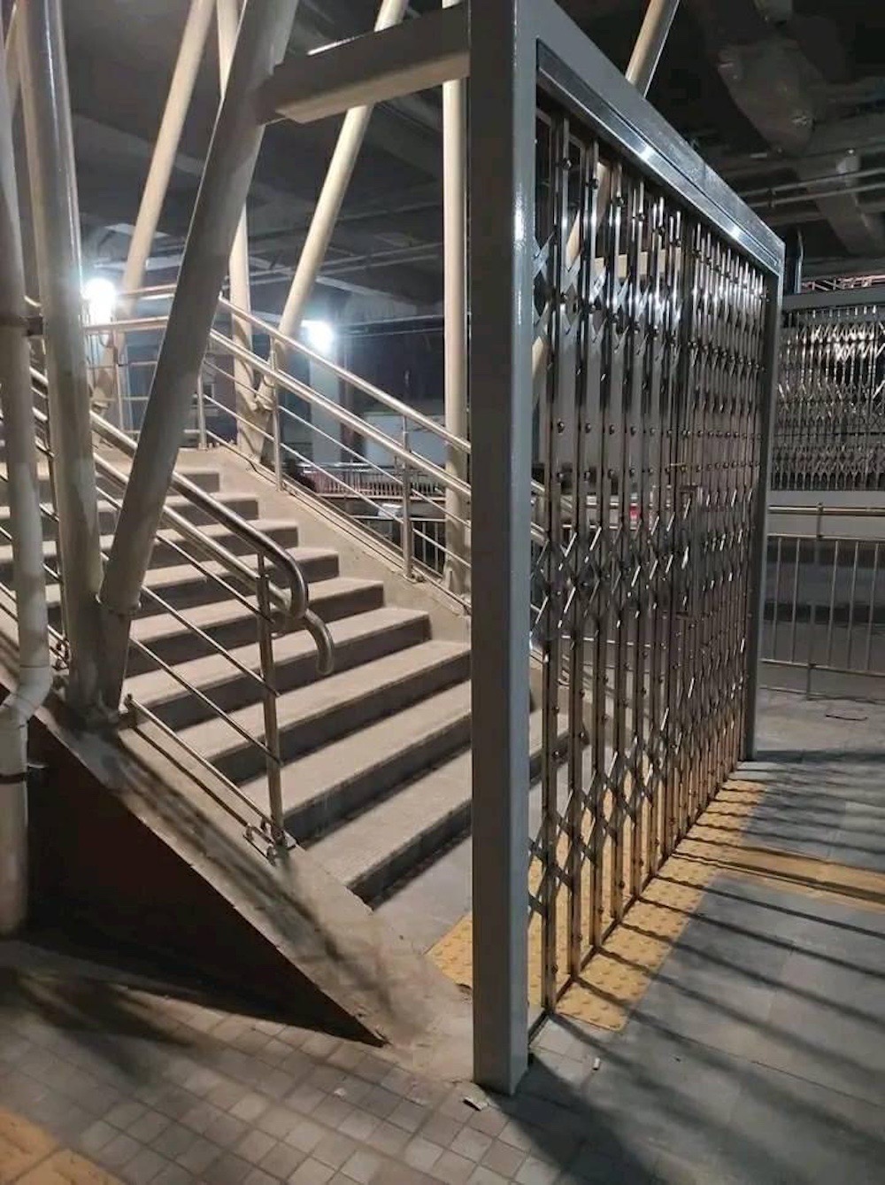 A photo of a gate with a very large gap next to it, allowing anyone to skirt right by the gate.